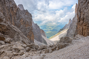 Mountain ravine with rocks in the Alps and a view of a valley