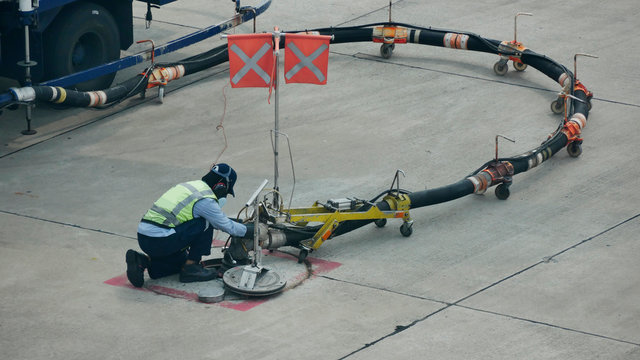 Refuel Truck For Airplane Parked And Waiting Refuel The Airplane On Ground In The Airport.Ground Technician Worker Refill Passenger Airplane Gasoline Fuel From Mobile Station Into An Airplane Wing