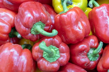 Red sweet bell pepper. Background of imperfect vegetables in a store or warehouse. Selective focus. Close-up.