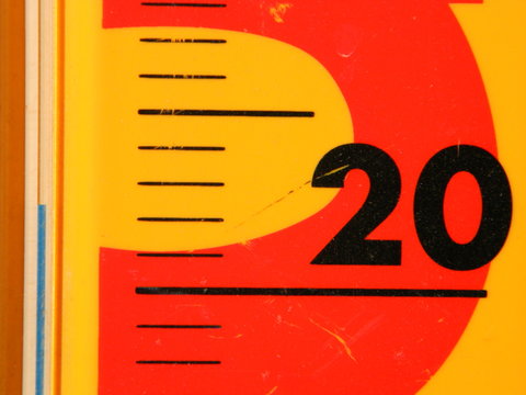 Close up image of a yellow and red thermometer indicating ideal air temperature (pleasant weather)