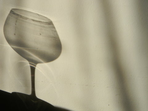 An empty wine glass shadow on the wall