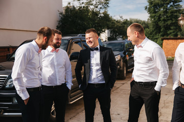 Groomsman spend time with groom at the backyard. Guys laugh and have fun