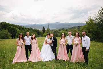 Groom and bride stand with groomsman and bridesmaid. Newlyweds kissing with friends. Wedding day....