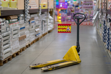 Yellow pallet truck for the transport of pallets in stock.
