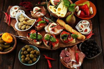 Italian antipasti wine snacks set. Cheese variety, Mediterranean olives, pickles, Prosciutto di Parma, tomatoes, artichokes