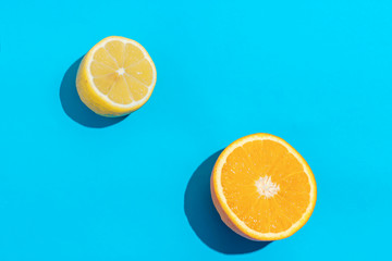 Top view of fresh lemon and orange isolated on blue background. Fruit minimal concept.