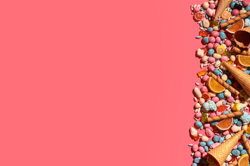 Various sweets, candys are palced on the photo on the coral background