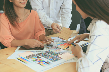 The designer team is meeting to select various colors and raw materials in product design.