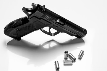 Black metal pistol lies on a white background, close-up