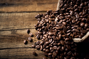 Ziarna kawy w jutowym worku na starych deskach © piotrszczepanek