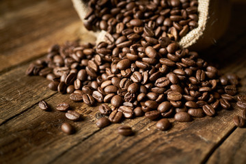 Ziarna kawy w jutowym worku na starych deskach © piotrszczepanek