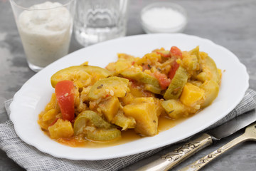 vegetable stew in white dish on ceramic background