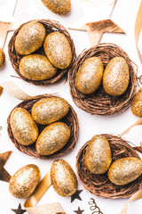 Golden glitter eggs in a nest. Easter background. Finance concept