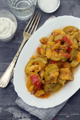 vegetable stew in white dish on ceramic background