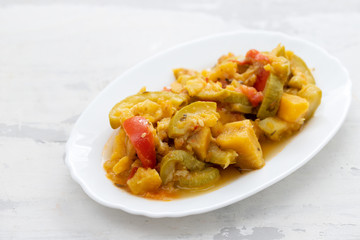 vegetable stew in white dish on ceramic background