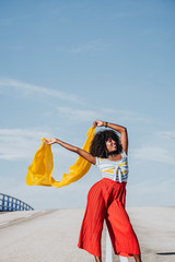 Afro woman with a yellow coloured scarf on the street