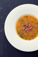 soup with smoked meat in white plate on ceramic dish