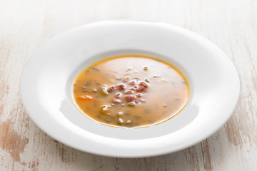 soup with smoked meat in white plate on wooden dish