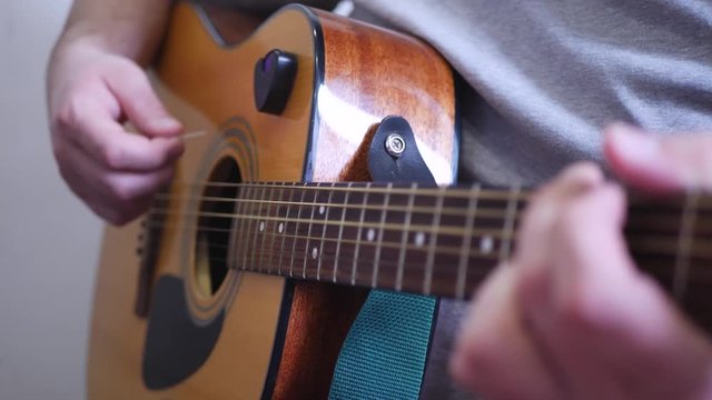 Man playing acoustic wooden six-string guitar