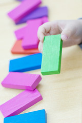 Focus on child's hand  playing with colorful wooden blocks in vintage color tone