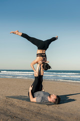 Young couple practicing acroyoga exercise