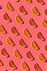 Pattern made of colorful candied fruits orange lemon on coral background. Flat lay. Minimal concept
