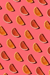 Fototapeta premium Pattern made of colorful candied fruits orange lemon on coral background. Flat lay. Minimal concept
