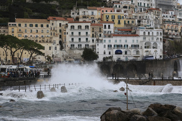 Amalfi Italien: Blick auf das stürmische Meer und die an steilen Hängen gelegenen malerischen bunten Häuser 