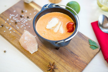 Chicken Soup. Homemade fresh creamy soup with chicken and vegetables in a black bowl close up.