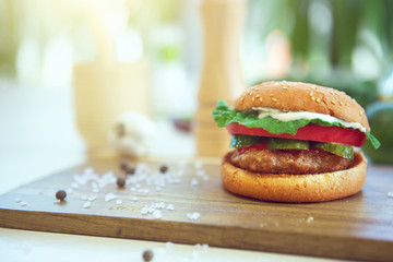Hamburgers and French fries on wooden tray.