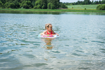 The child swims on an inflatable circle.