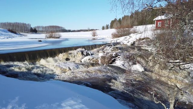 Nautelankoski, Lieto, Finland on winter. River Aura (Aurajoki in Finnish) is still frozen, but water flowing after dam.