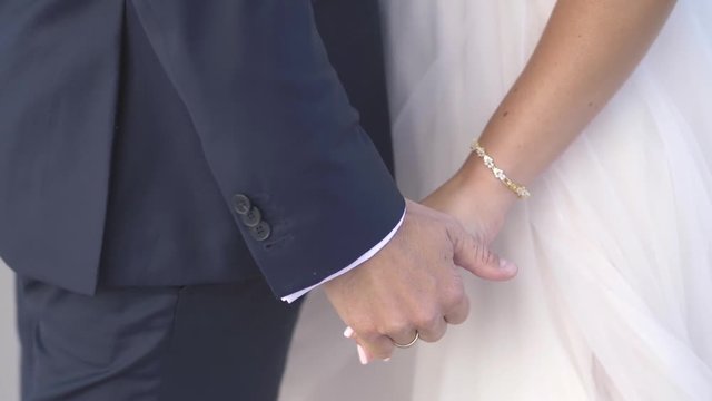 bride and groom holding gands at wedding