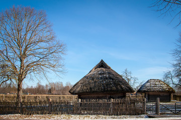 Fototapeta na wymiar Old house with a straw roof in the blue sky in the spring