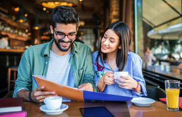 Couple on coffee break. Young students learning in the cafe for seminar. Education, relationships, love concept