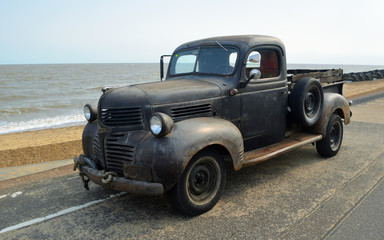  Rusty Classic Piick up truck  parked on seafront promenade.
