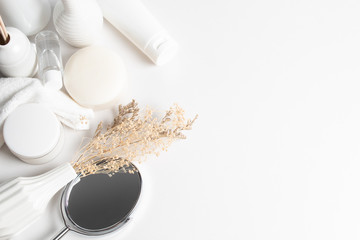 top view of medical skincare treatment spa cosmetic with white tone decoration and dried herb flower and mirror and aroma perfume