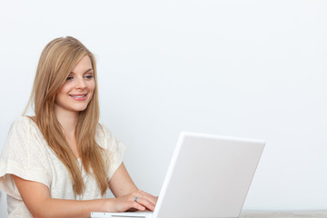 Fototapeta premium Young woman using a notebook computer indoors