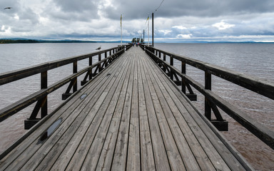 Fototapeta premium Long wooden pedestrian pier jutting out in Siljan Lake - Rattvik, Sweden.