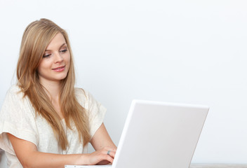 Fototapeta premium Young woman using a notebook computer indoors