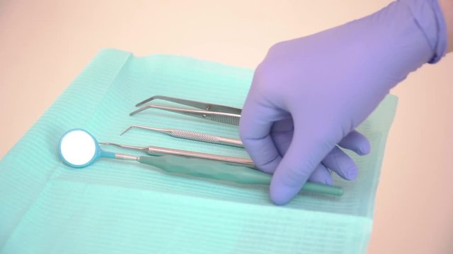 The Intern lays out clean dental instruments on a sterile napkin. Sterilization of medical instruments at the dentist. Top view, close-up
