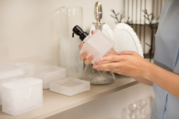 Cropped close up of a woman holding soap dispenser examining it while shopping at houseware store...