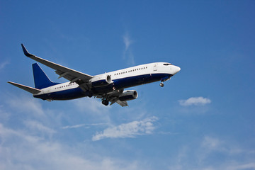 Fototapeta na wymiar flying plane in blue clear sky close-up