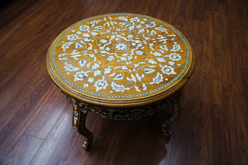 Antique coffee table with flower patterns. There are handcrafted mother of pearl inlays on the table.