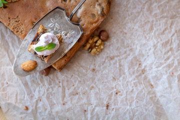 a slice of hazelnut pie with almonds and peanuts on the table