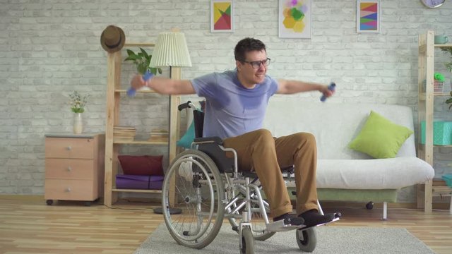 strong paralyzed male wheelchair athlete in sweat doing dumbbells