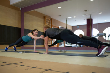 Fitness parners in sportswear doing exercises at gym. Fitness sport gym concept