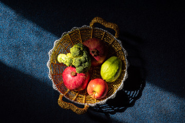 Creative moody shot of fruit and vegitable in a golden basket