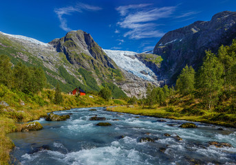 Naklejka na ściany i meble Norwegian landscape with milky blue glacier river, glacier and green mountains. Norway