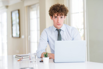 Fototapeta premium Young business man working with computer laptop at the office depressed and worry for distress, crying angry and afraid. Sad expression.